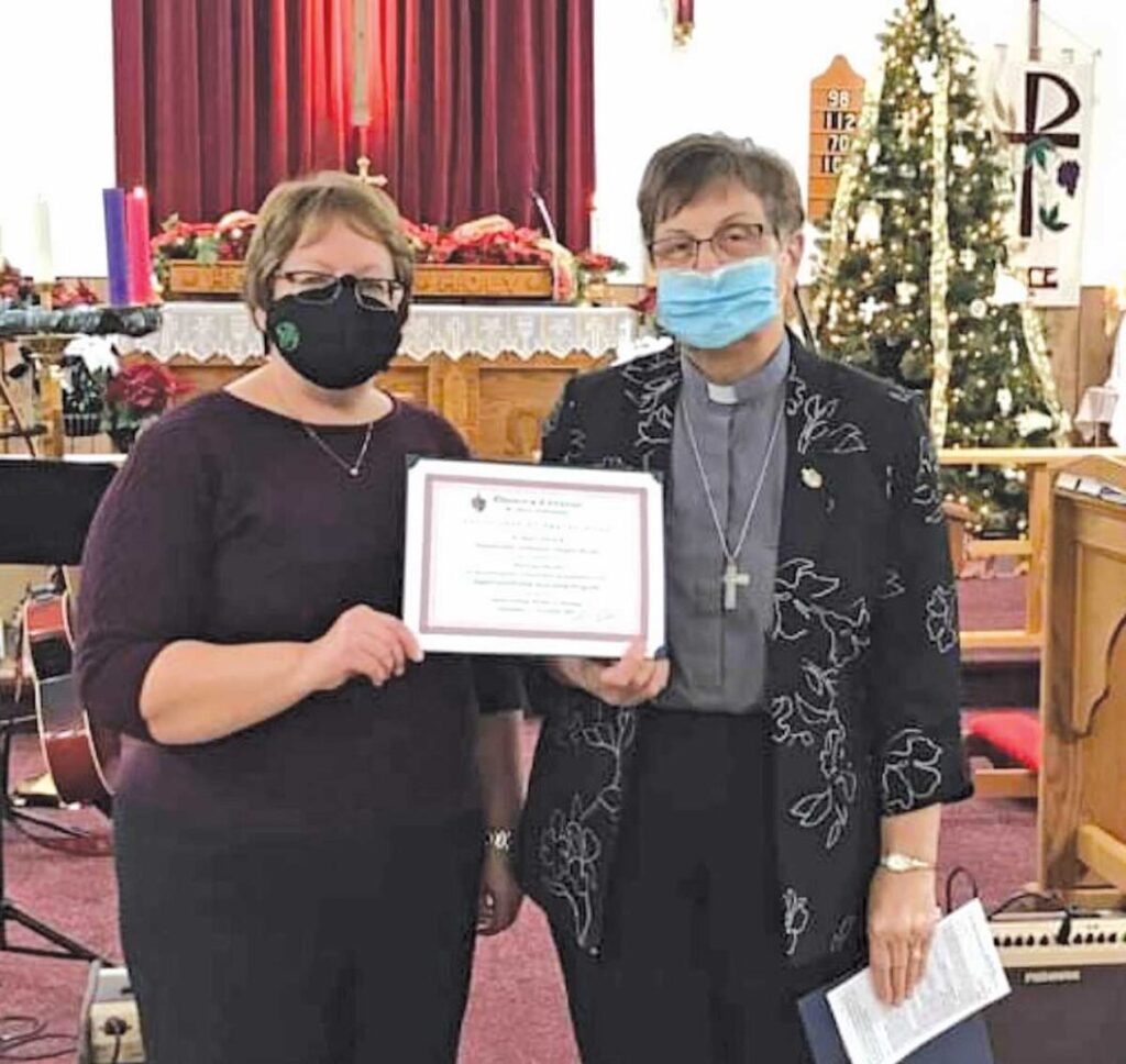Shelly Loder accepting a certificate of appreciation from Rev’d Kay, also recognizing St. Paul’s as a “Teaching Church.”