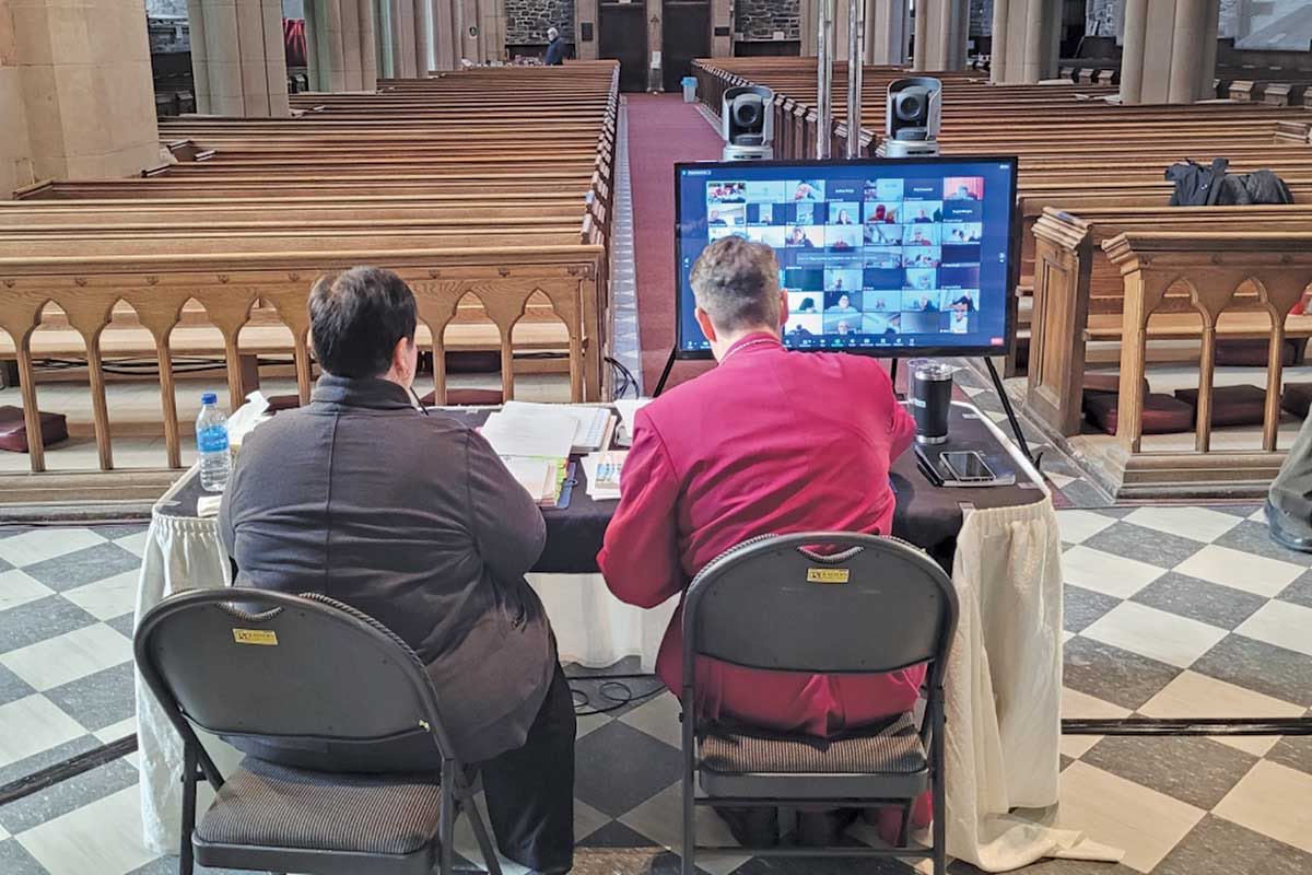 Archdeacon Taylor and Bishop Rose watch the synod delegates on Zoom