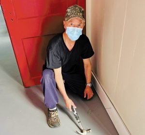 man installs baseboards
