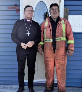 bishop and man survey damage after hurricane Fiona