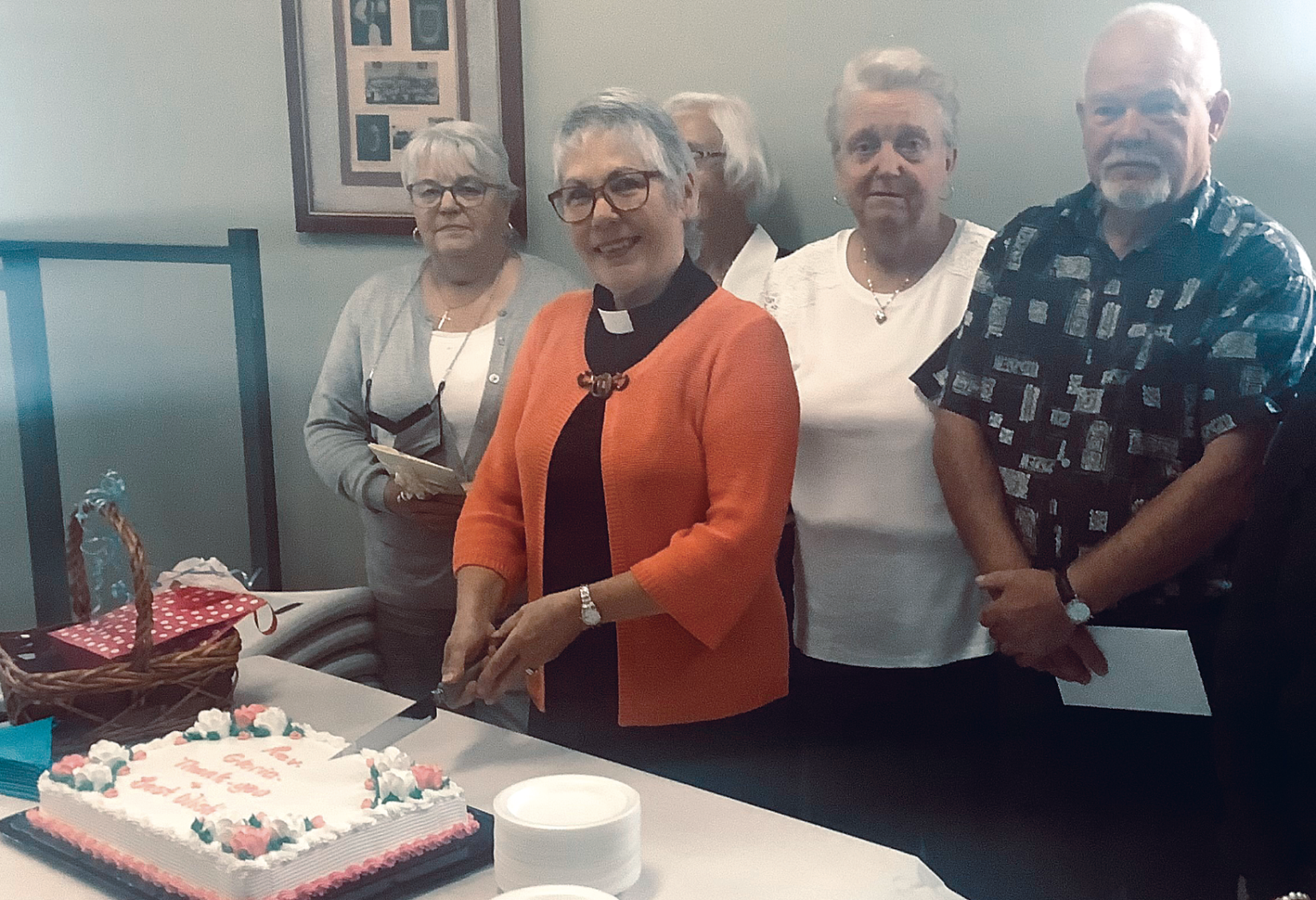 Priest cutting cake at leaving party