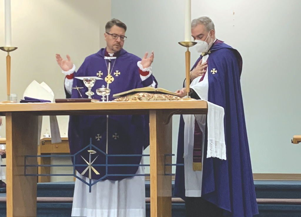 a bishop and a priest at an altar