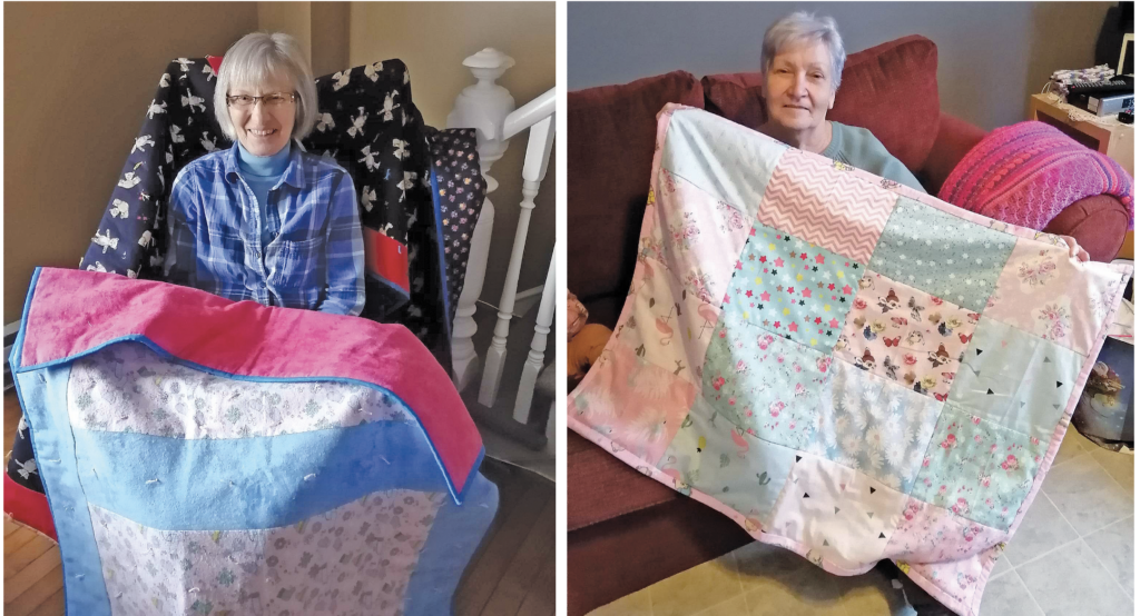 two women with quilts that they have made