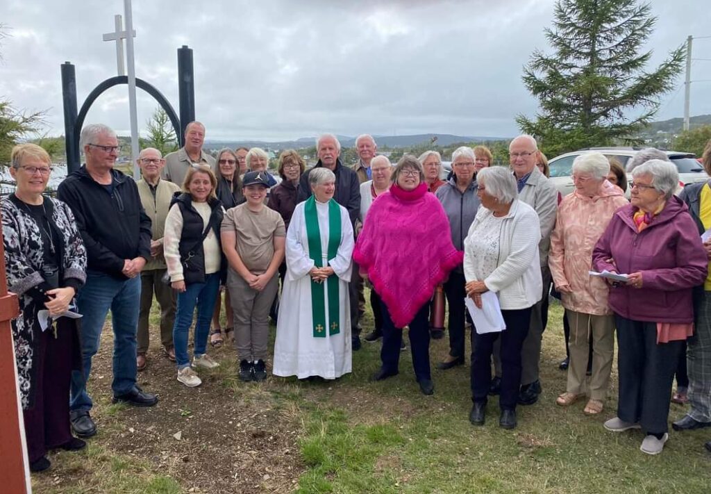 Anglican priest and people gathered together for dedication of church bell in Spainard's Bay, Newfoundland.