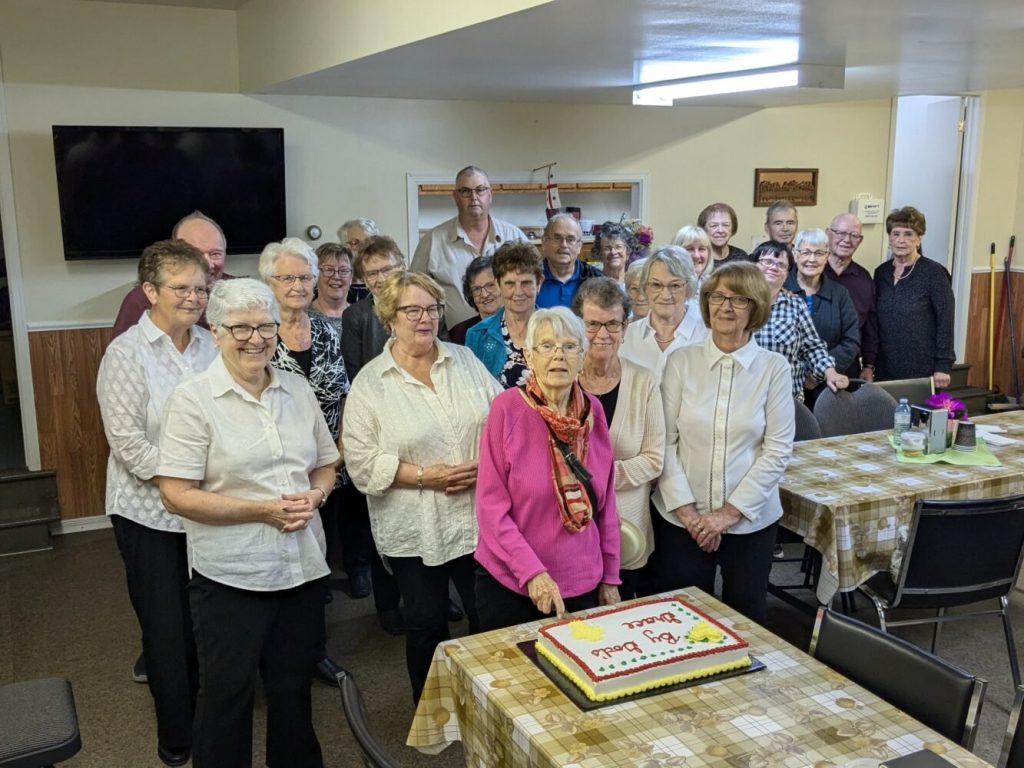 group of people gathered around a cake