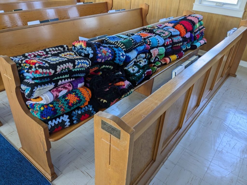 Crocheted blankets on a church pew