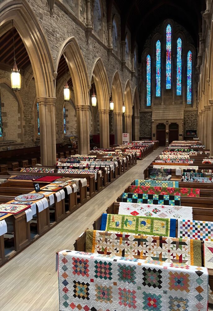 stone cathedral with quilts displayed on pews