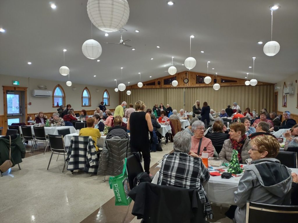 church hall filled with folding tables and people enjoying a fall sale