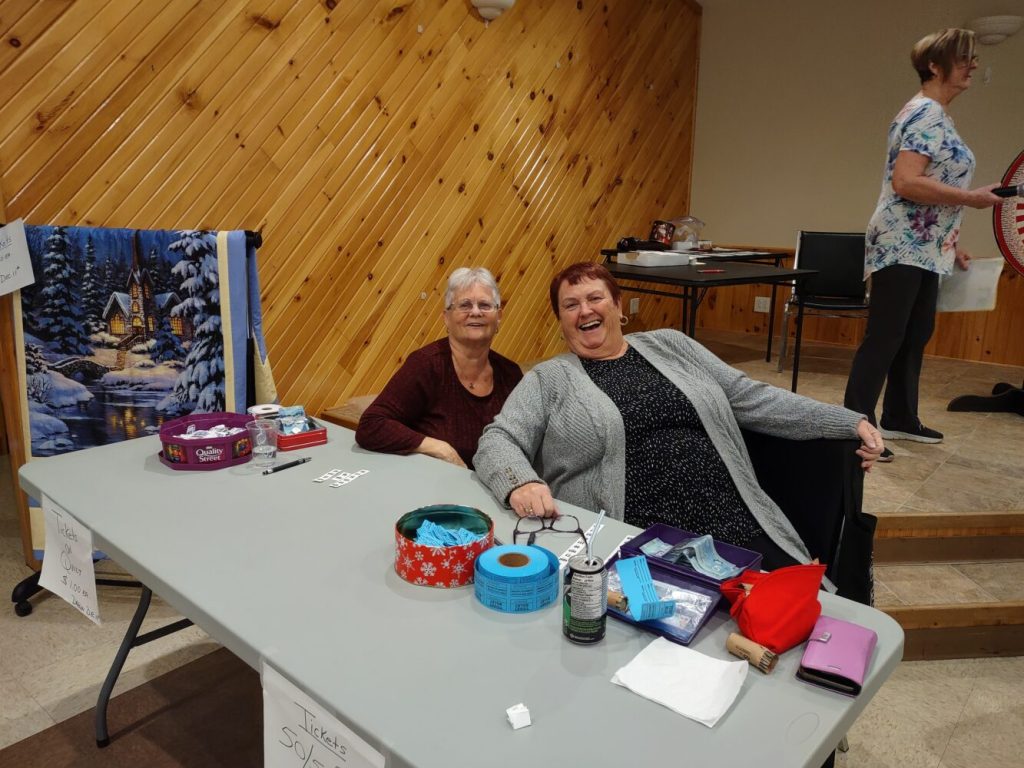 two women at a table at a church fall sale