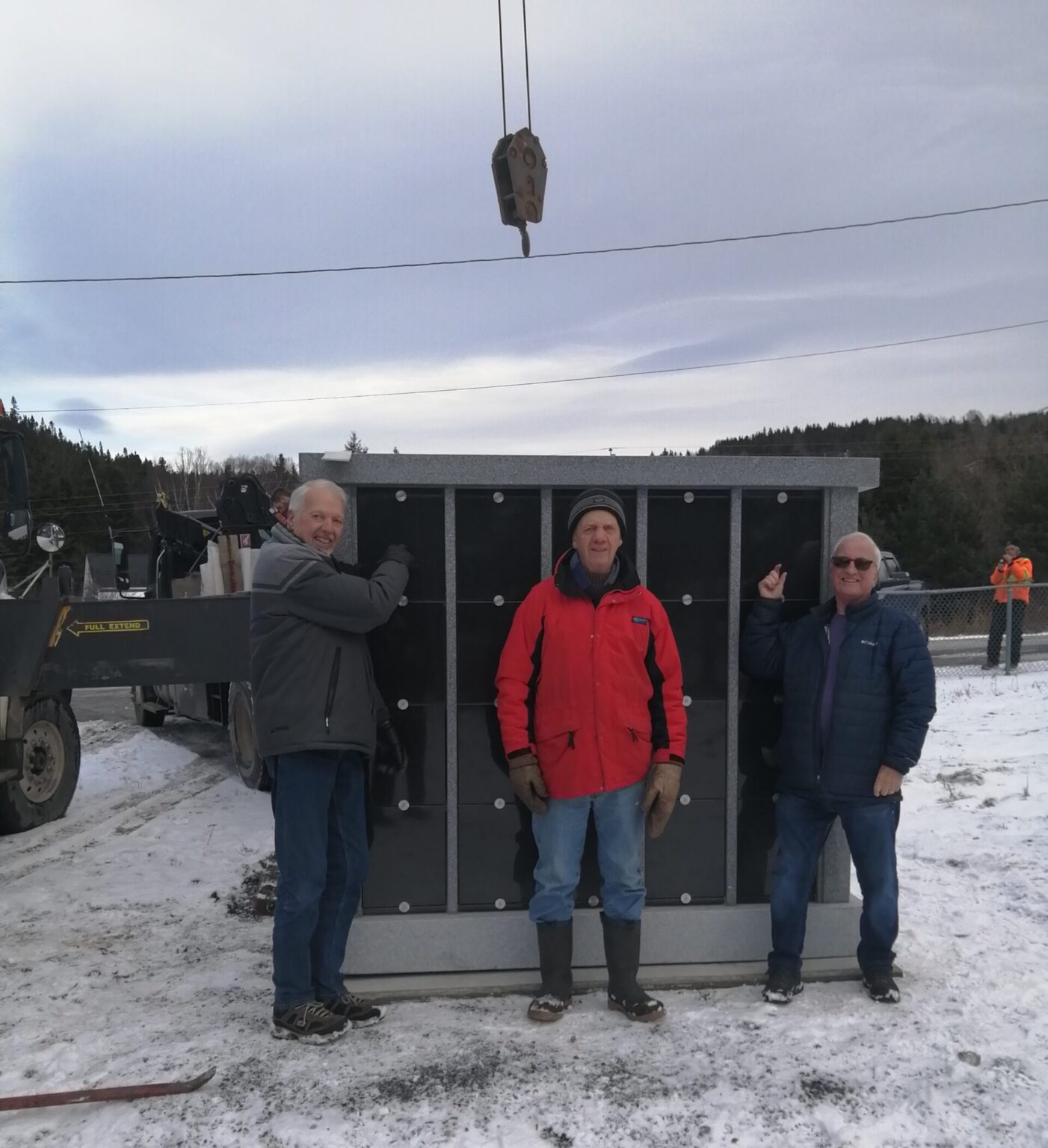 three men stand in front of a new columbarium