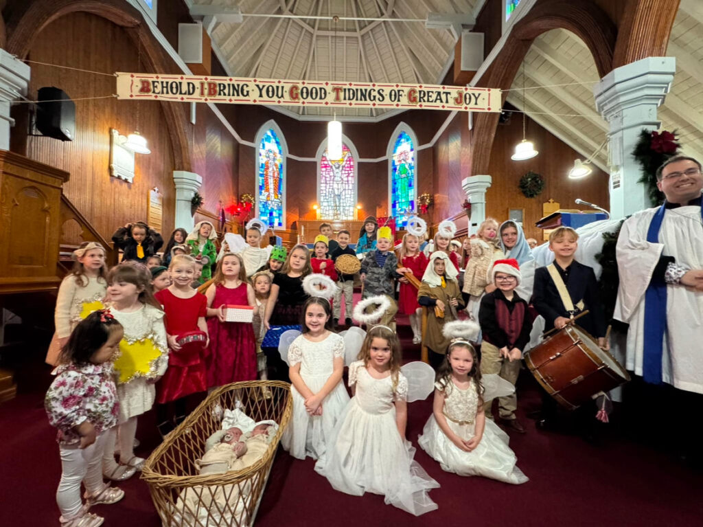 children dressed in costumes for a nativity play at the front of a church