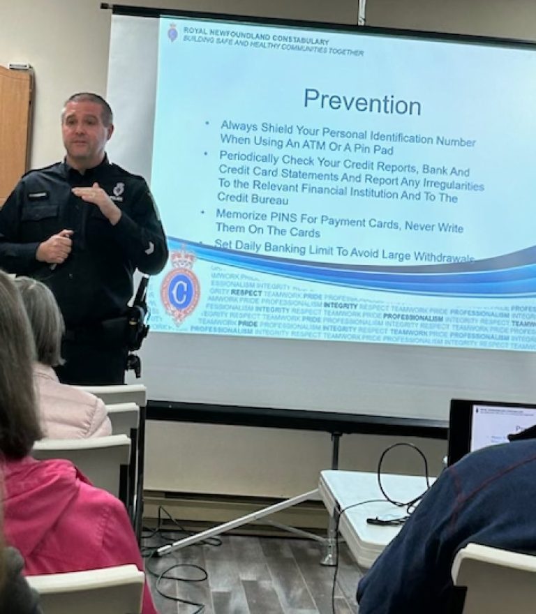 a man who is a member of the local police force giving a seminar on protecting seniors against fraud