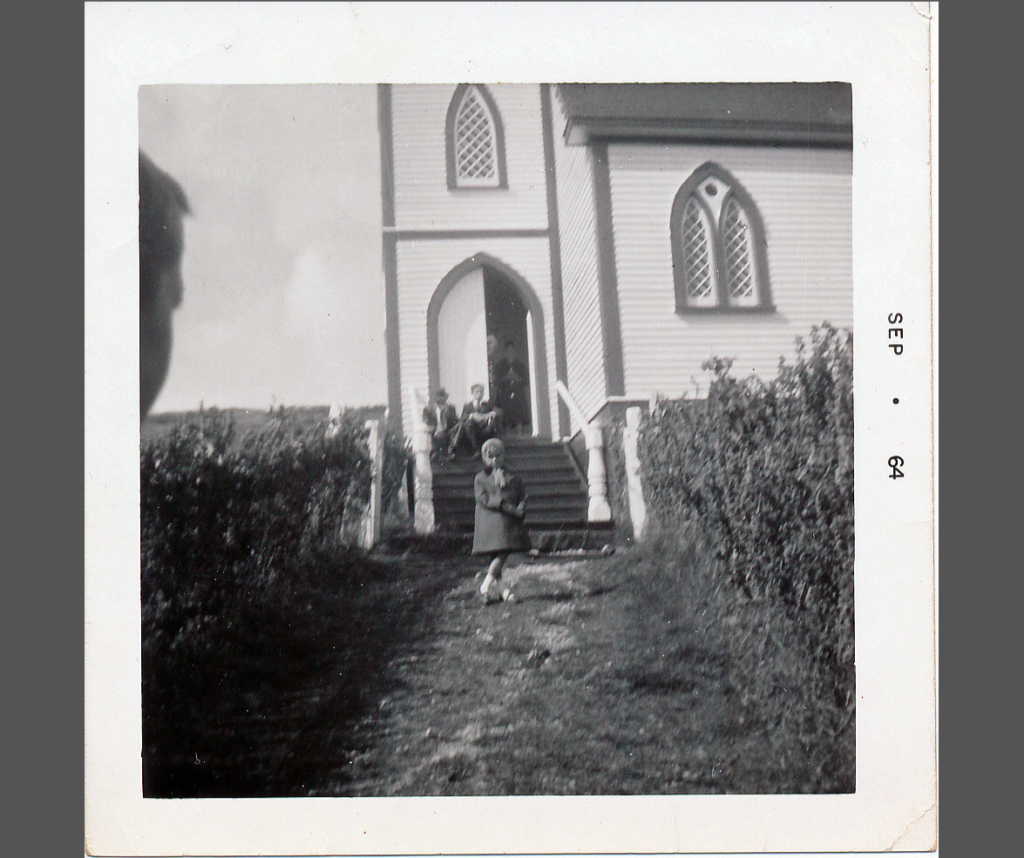 a young girl in front of a church in St. Jacques, Newfoundland, in 1964