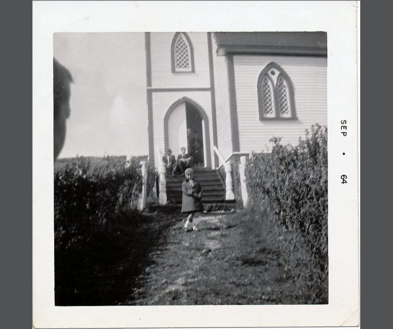 a young girl in front of a church in St. Jacques, Newfoundland, in 1964