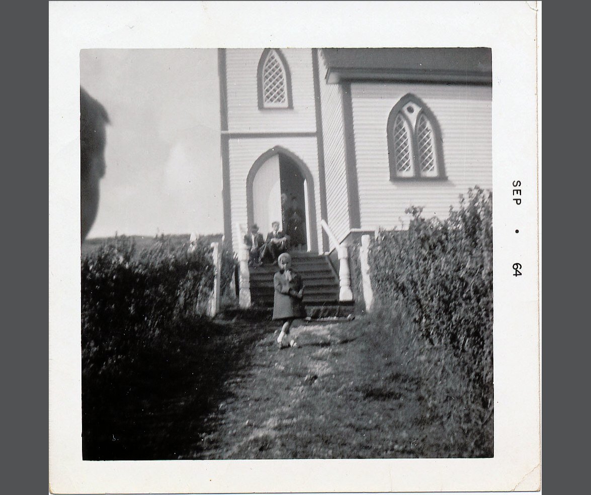 a young girl in front of a church in St. Jacques, Newfoundland, in 1964