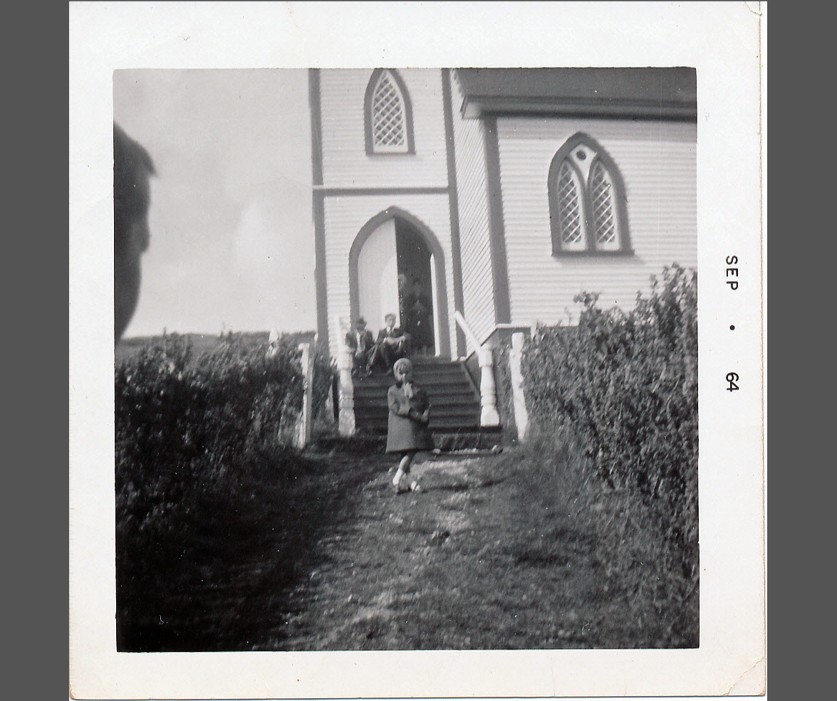 a young girl in front of a church in St. Jacques, Newfoundland, in 1964