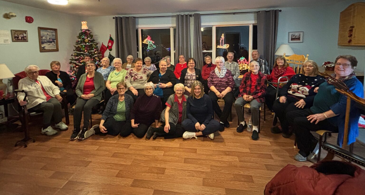 women's group sitting in the community room of a nursing home with residents during Christmas