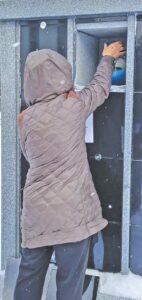woman places the urn of her deceased friend in a new columbarium 