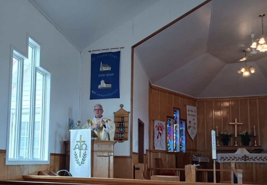 a man preaches from the pulpit in a church in rural Newfoundland