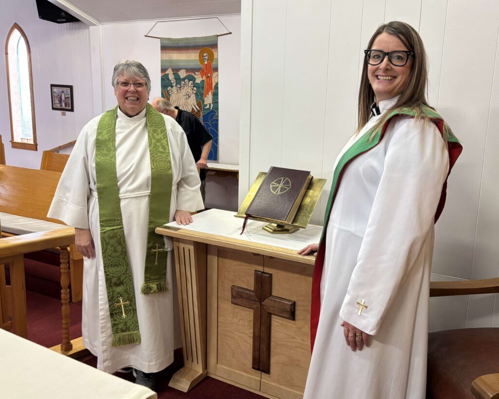 two women, dressed as Anglican clergy, stand next to a new credence table