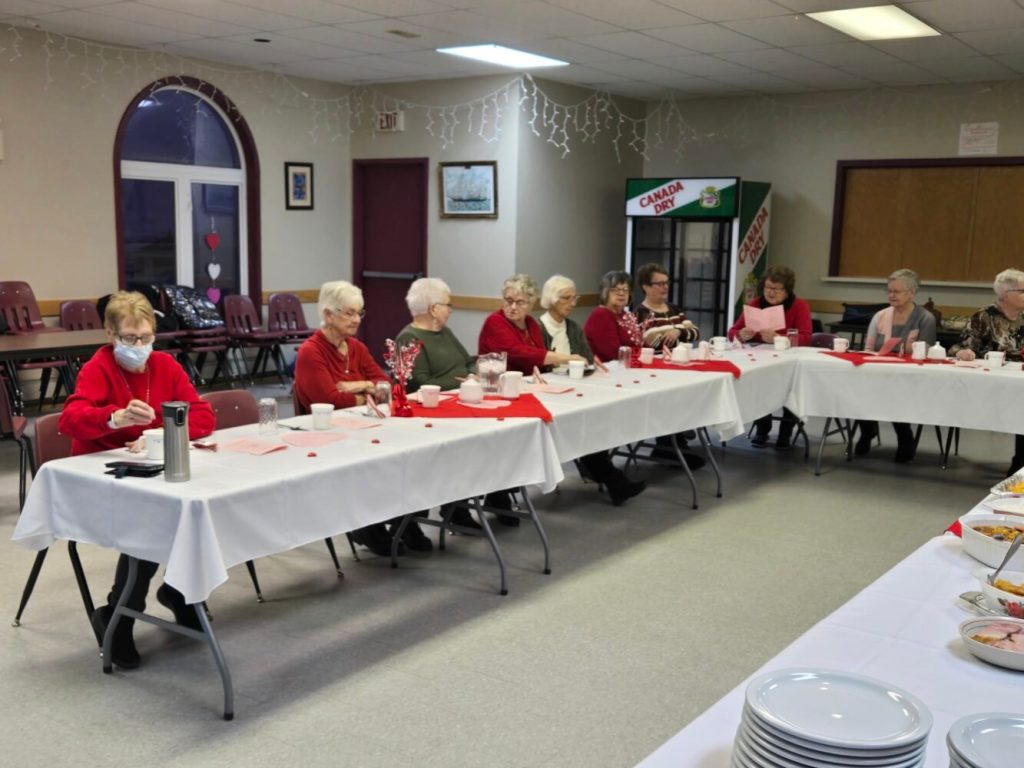a group of people seated at a table for a Valentine's celebration