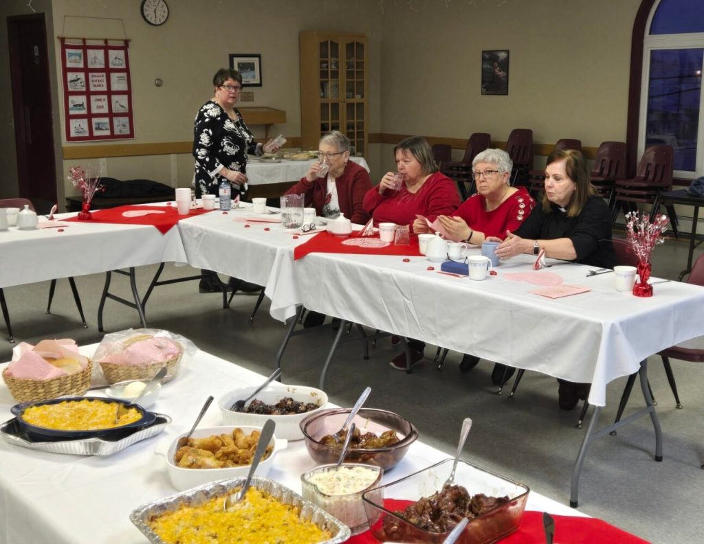 a group of people seated at a table for a Valentine's celebration