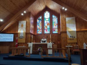a man dressed as a priest standing behind an altar