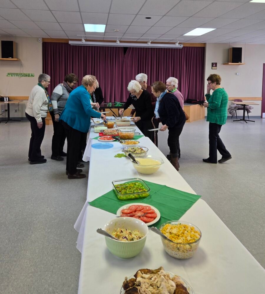 women getting foor at a buffet in a church hall