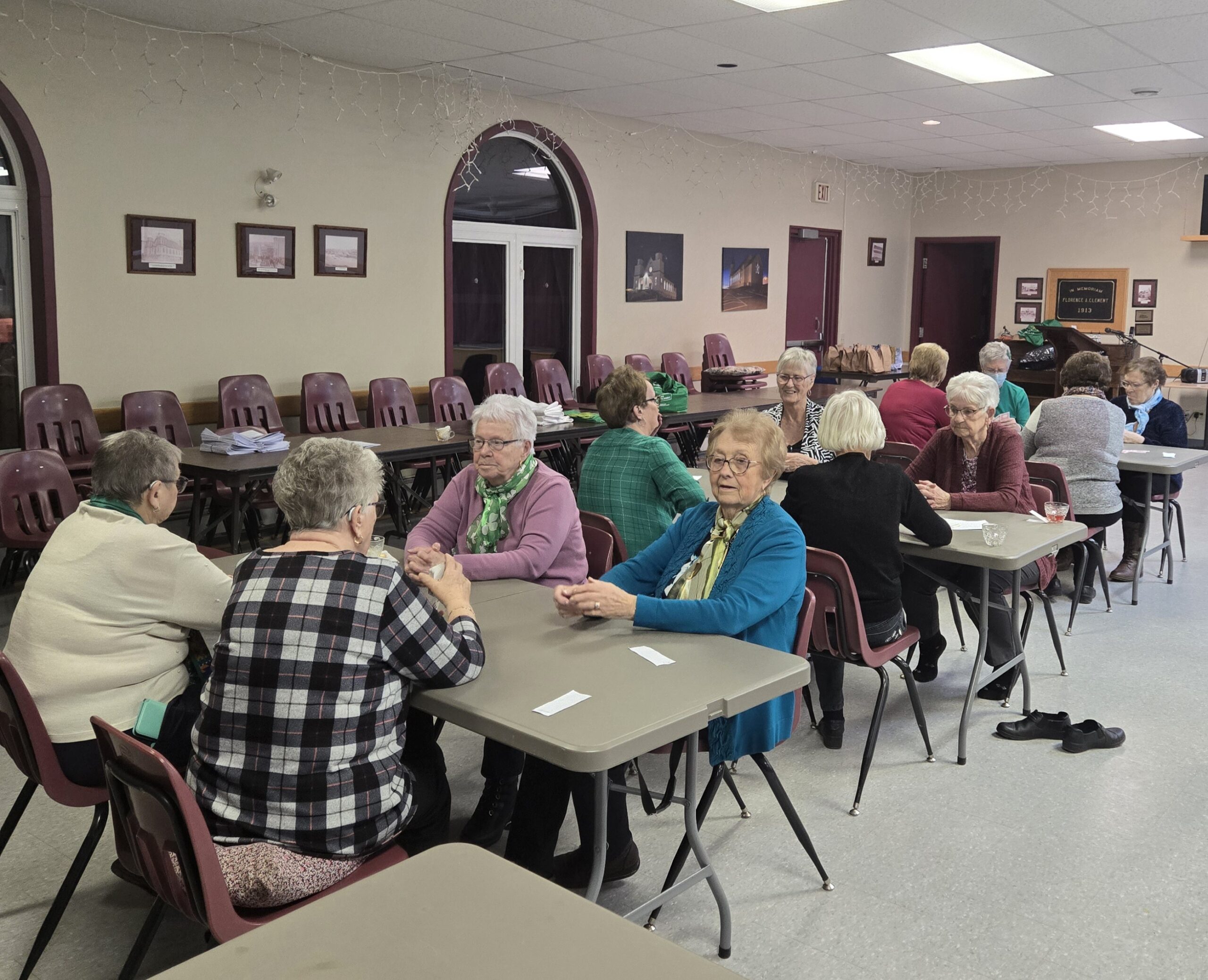 women sitting at folding tables in a church hall
