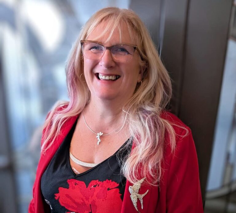 a blonde woman wearing red and smiling