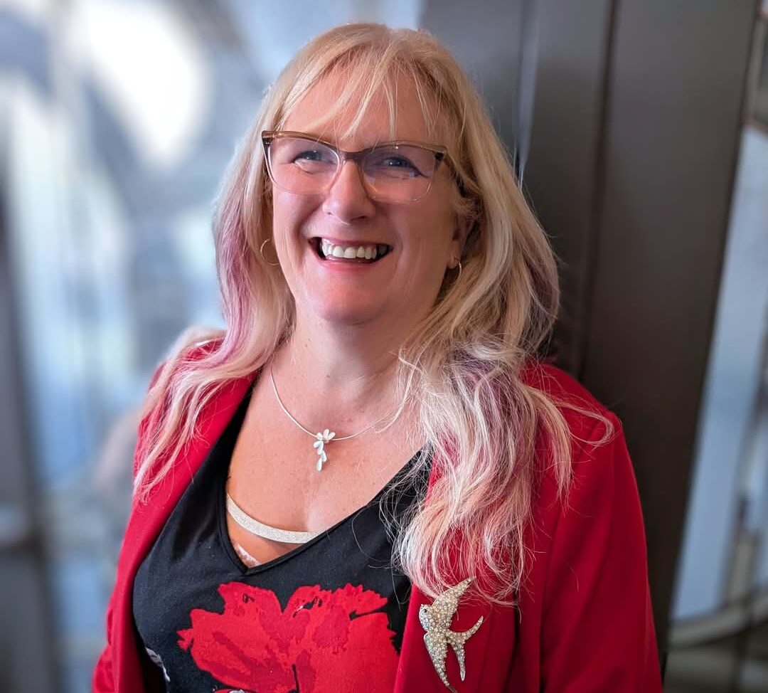 a blonde woman wearing red and smiling