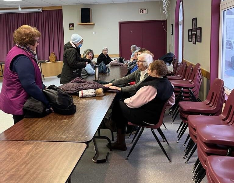 women sitting at a table in a church hall