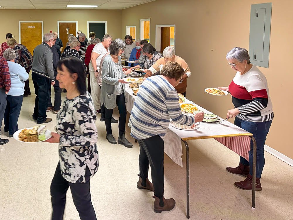 People at a buffet table in a church hall