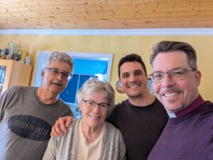 four people in a yellow room smile for the camera
