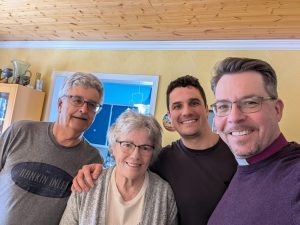four people in a yellow room smile for the camera