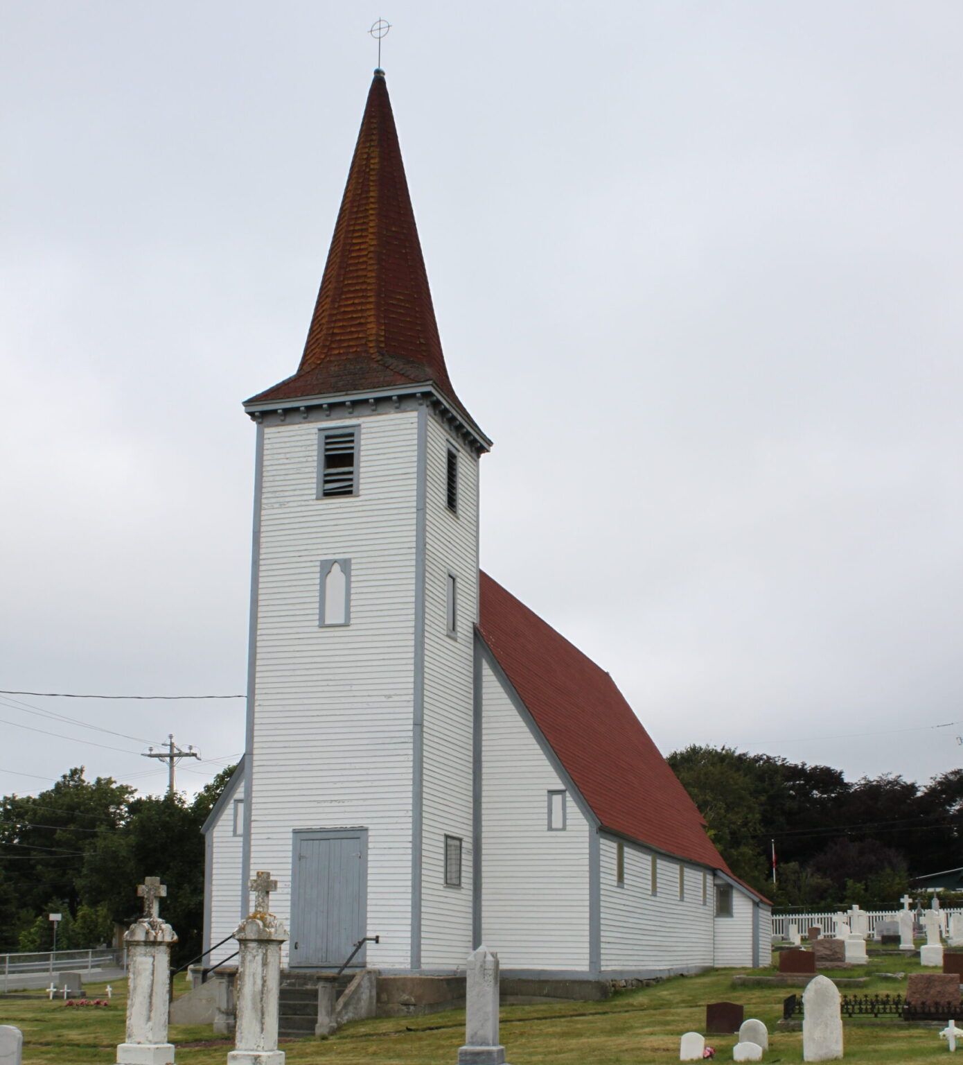 and old wooden church with a red roof and a tall steeple