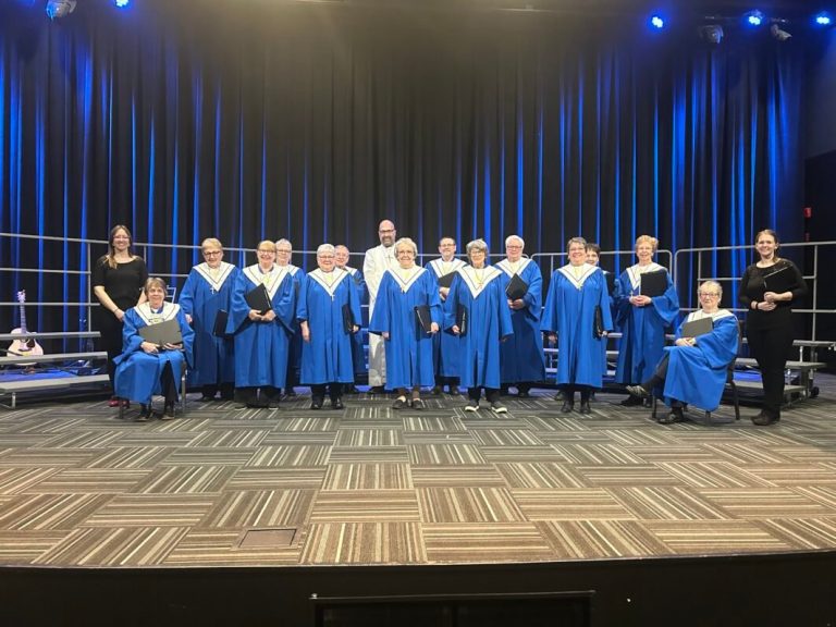 a group of people in blue robes on a stage.