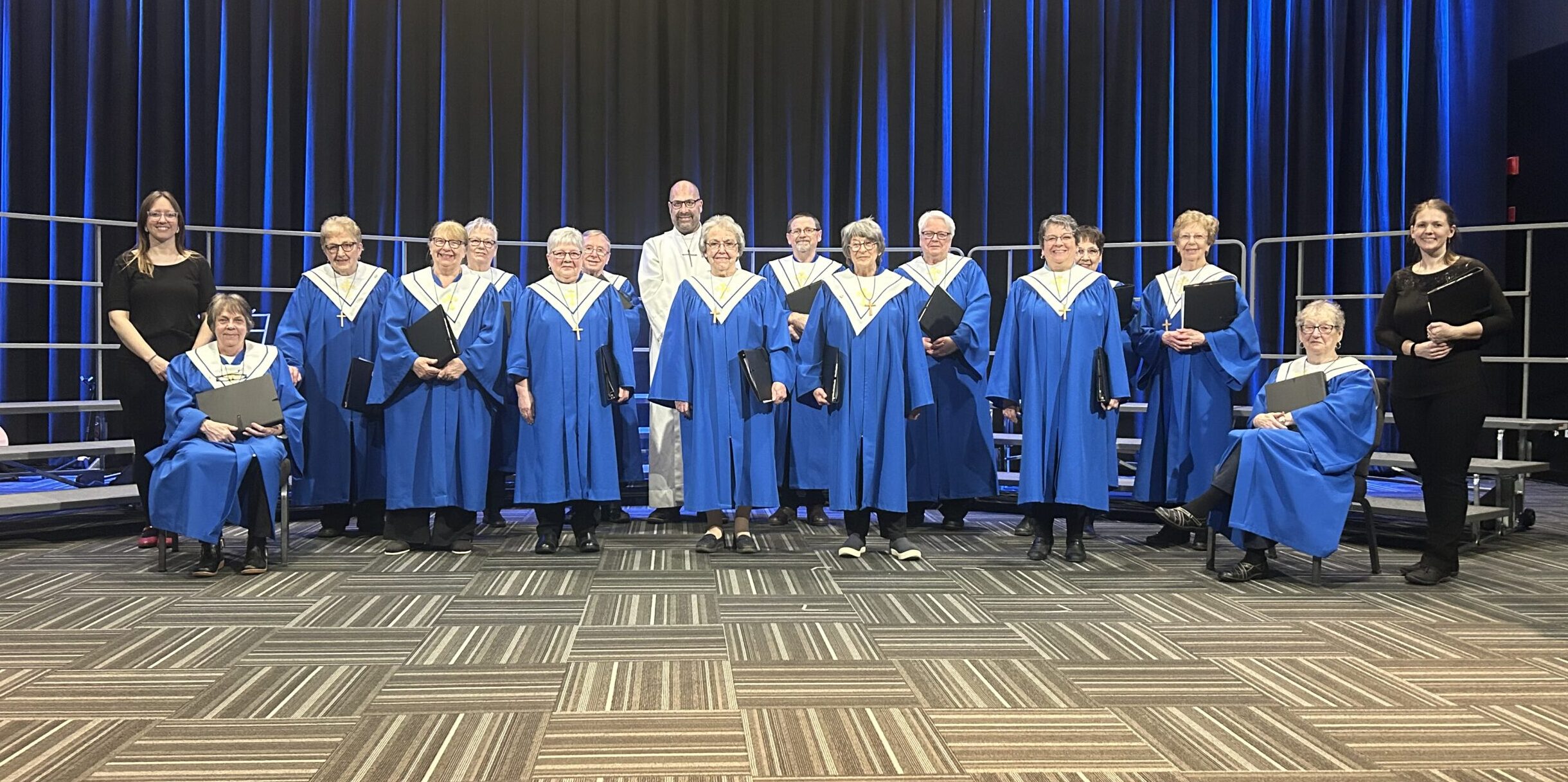 a group of people in blue robes on a stage.