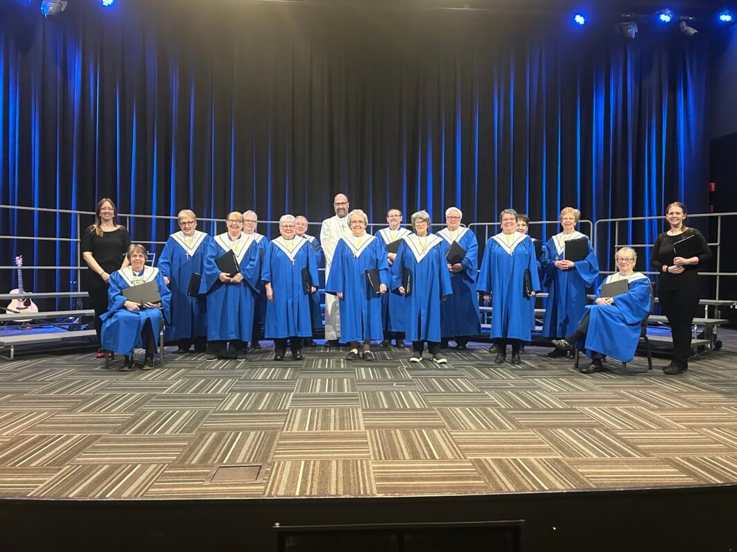 a group of people in blue robes on a stage.