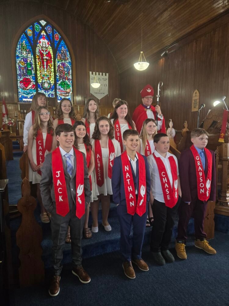 A group of children and a bishop standing in a church.