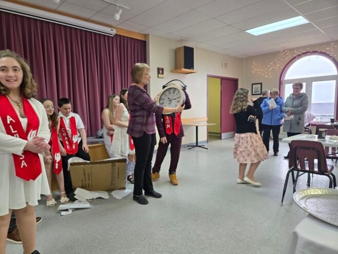 a woman receives a large clock as a gift