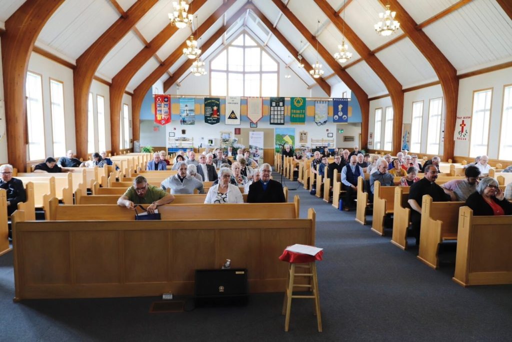 many people in the pews of a large wooden church