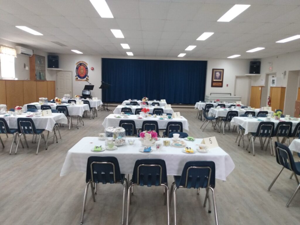 A room with many tables set for a meal.