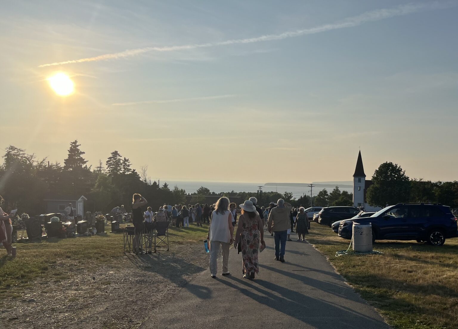 group of people gathered in a cemetery at sunset