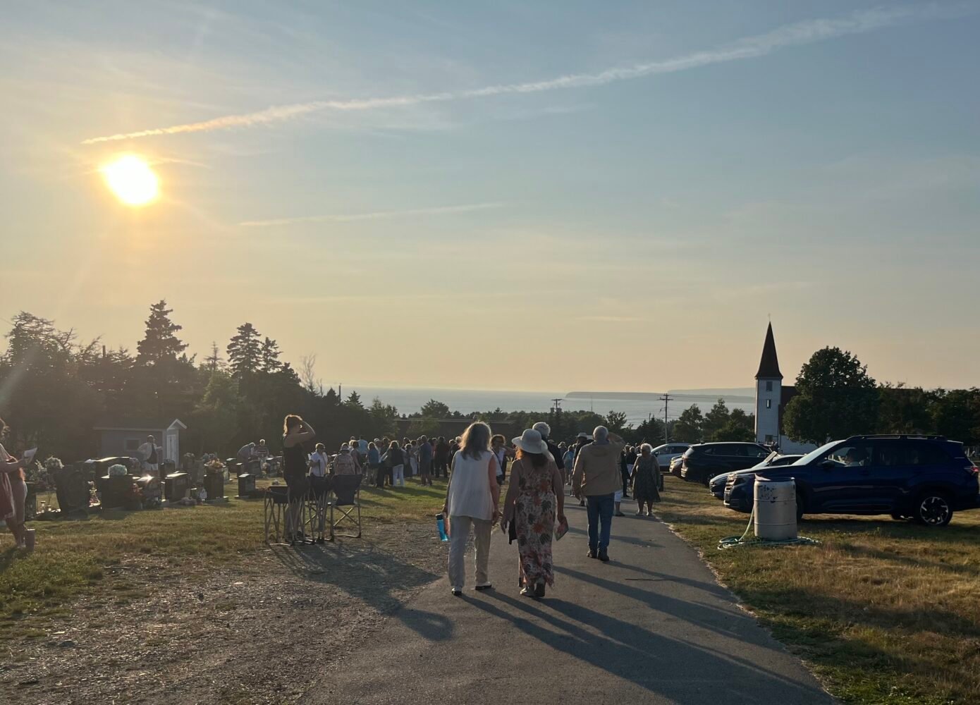 group of people gathered in a cemetery at sunset