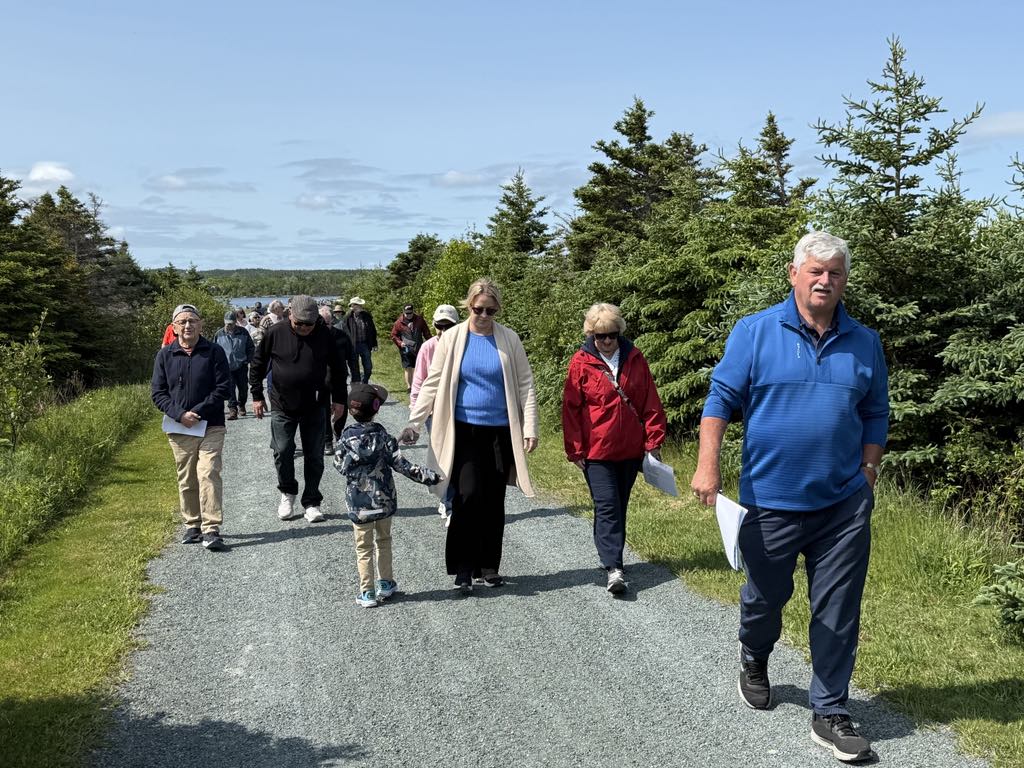 a group of people walking on a gravel trail
