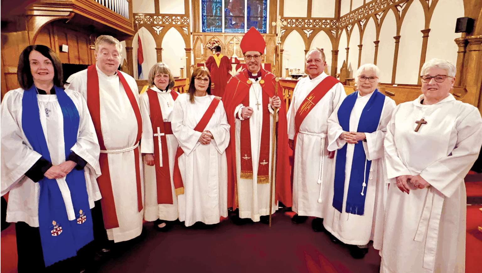 a group of Anglican clergy at the front of a wooden church