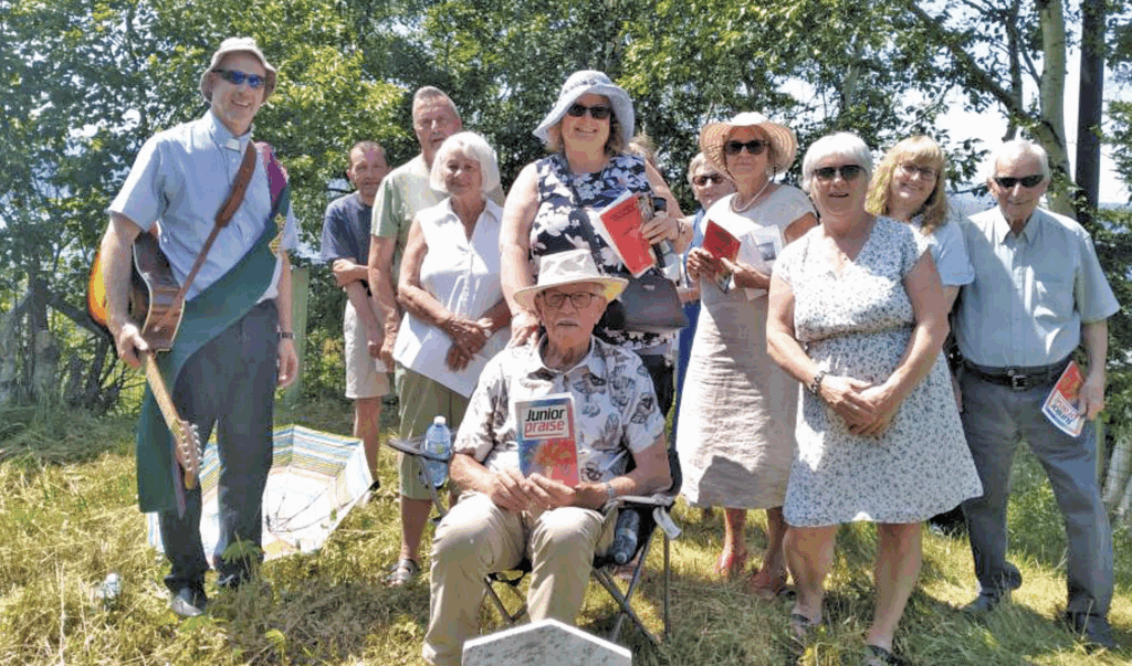 A group of people standing and sitting outdoors