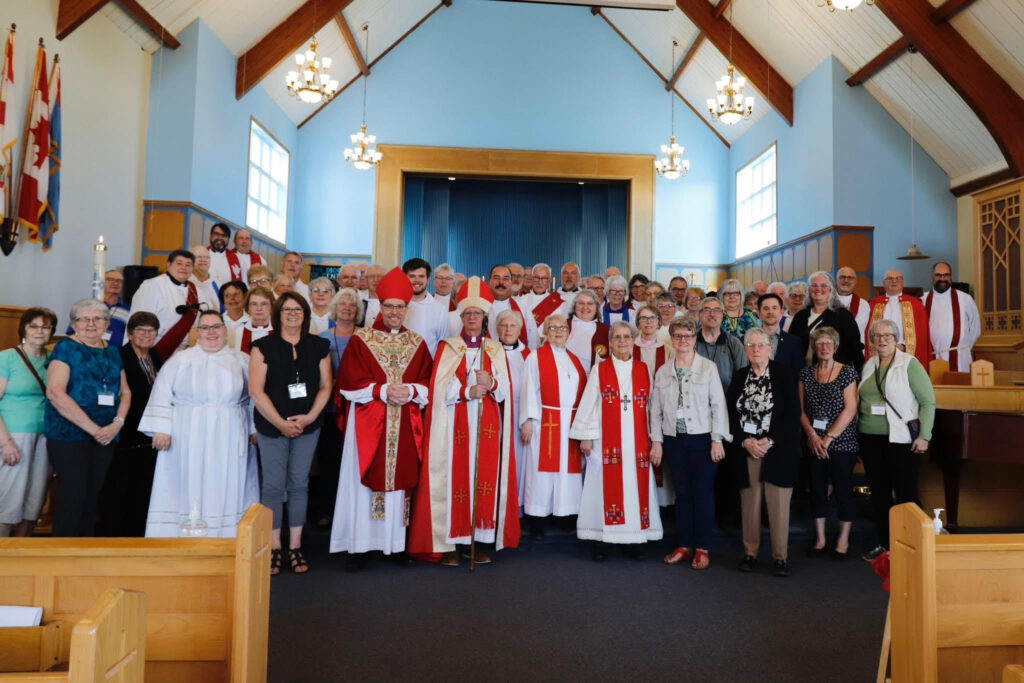 a group of people, some dressed as members of the clergy of the Anglican Church, at the front of St. Martin's Cathedral in Gander