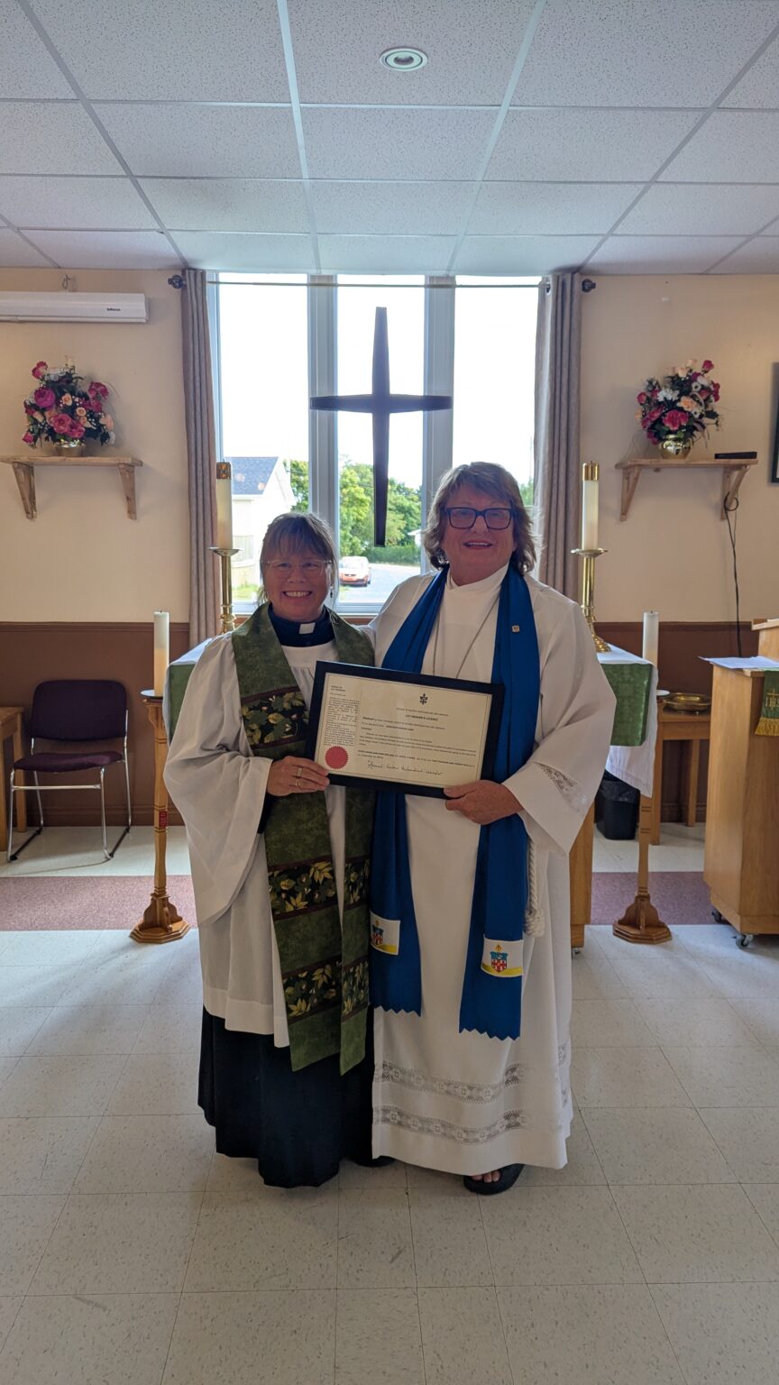 two women, one dressed as a priest and one as a lay reader, in front of an altar